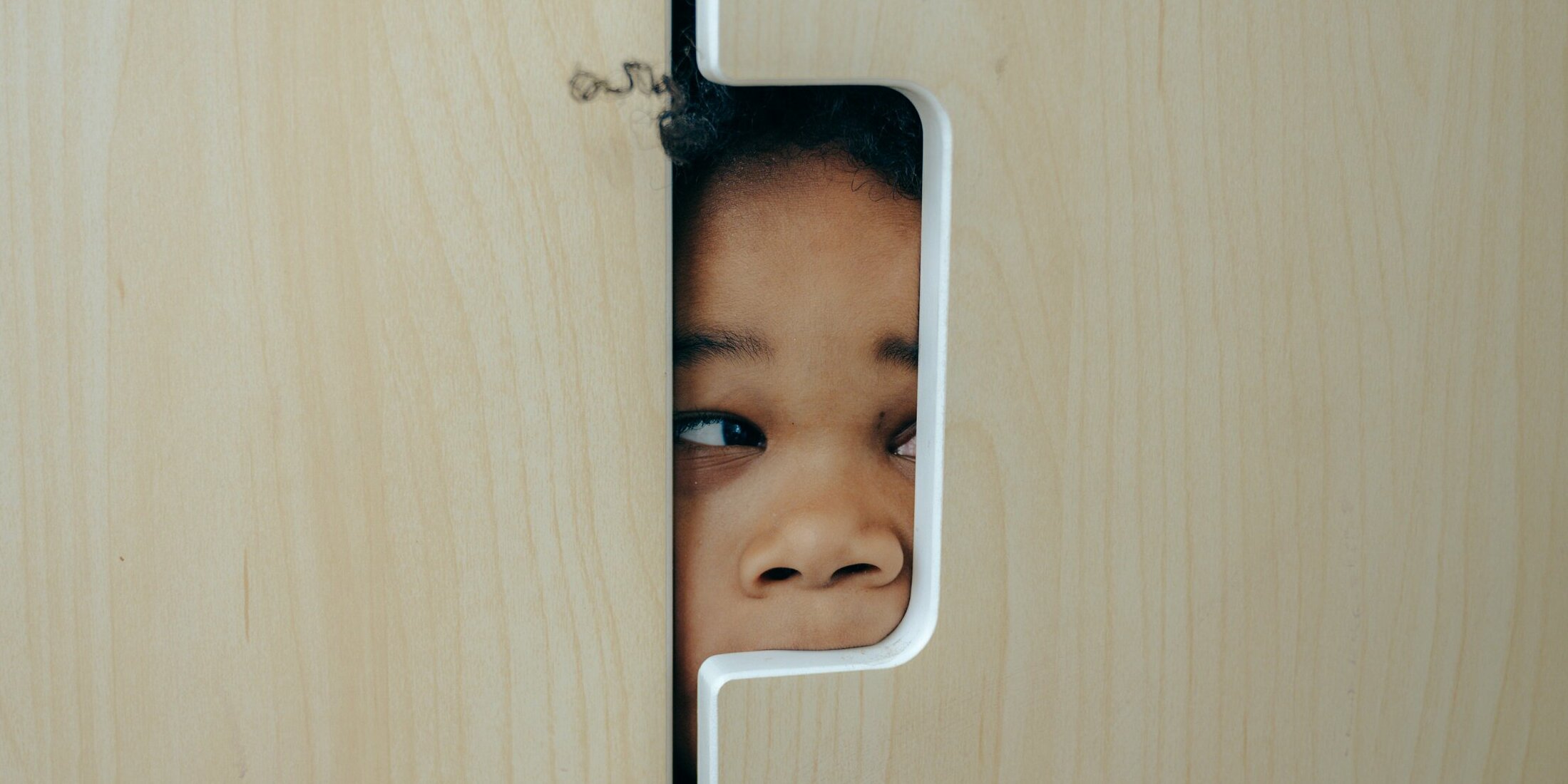 Page Teaser Little girl sneak peaking through a wall